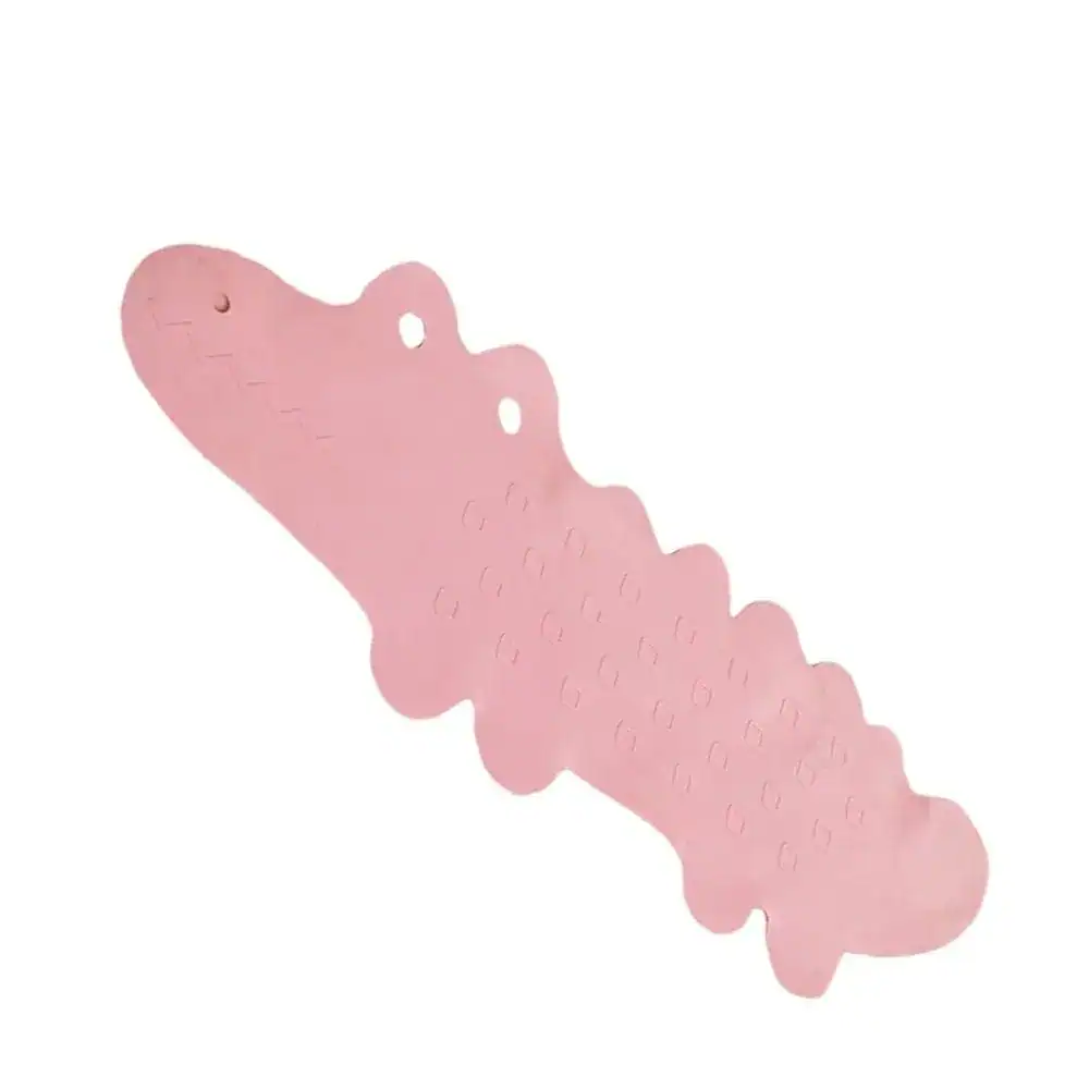 Pink badrumsmatta i form av krokodil för barn, med textur och hål för hängning.
