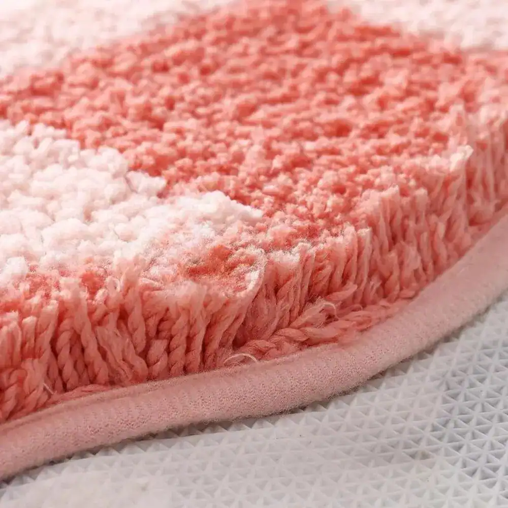 Blomformad rosa badrumsmatta med mjuk fluffig textur och färgglad gradient.