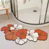 Badrumsmatta med blommor i röd och vit färg, placerad framför duschen.