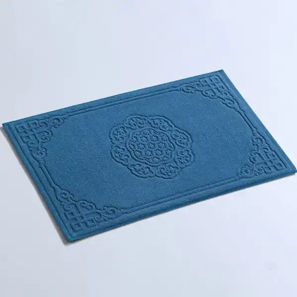 Blå badrumsmatta i bomull med broderad prydnad, idealisk för badrummet.