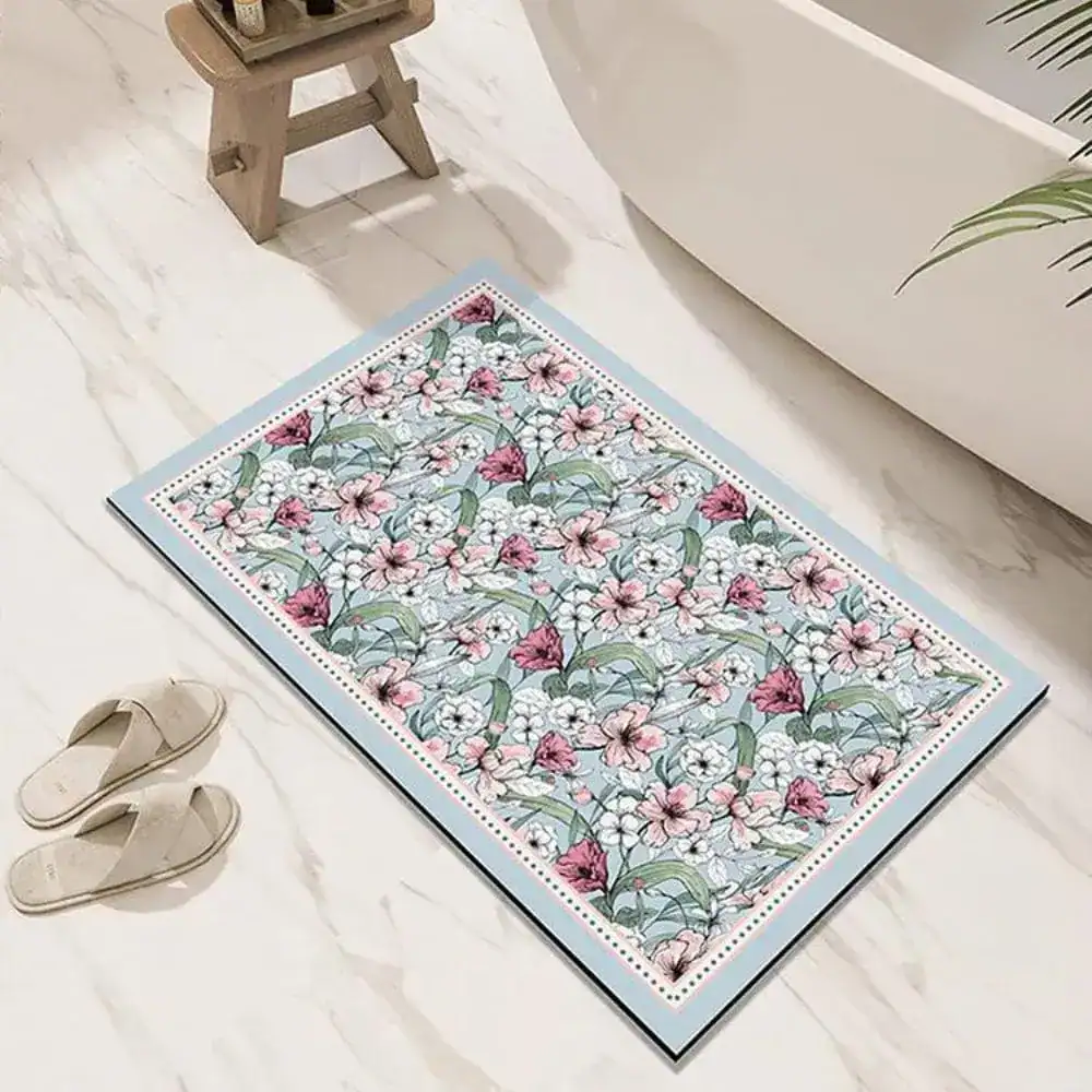 Badrumsmatta Diatomit Orientalisk med blommönster i rosa och vit på ljusblå bakgrund.