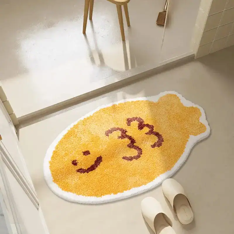 Badrumsmatta i form av fisk med leende ansikte och text 333, gul färg, badrumsmatta.
