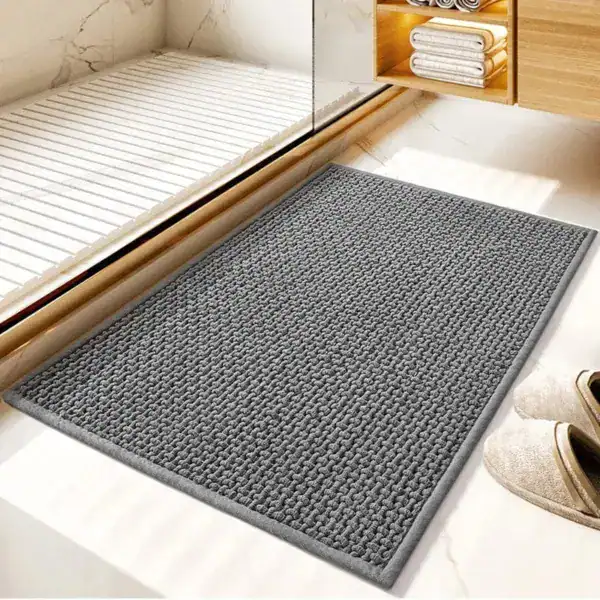 Grå flätad badrumsmatta med texturerad yta, idealisk för badrummet med modern design.