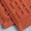Badrumsmatta frotté i rustikt orange, texturerad yta med rutig mönster och mjuk kvalitet.