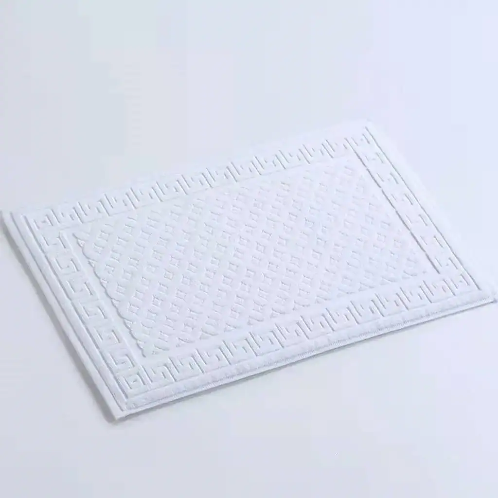 Badrumsmatta frotté vit med geometriskt mönster och gräskant.