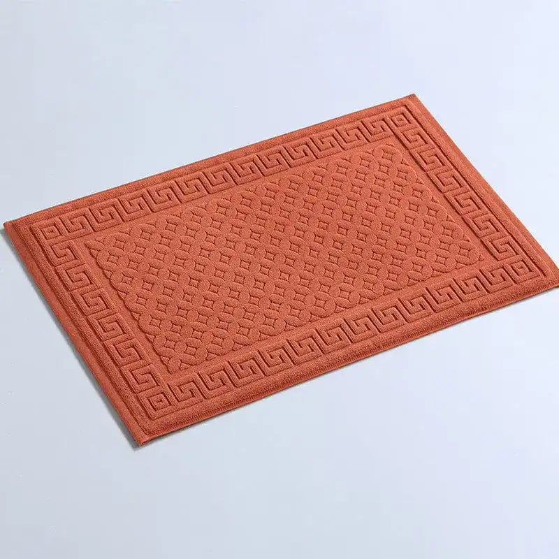 Badrumsmatta frotté i rustikt orange med geometriskt mönster och grekiskt randmönster.