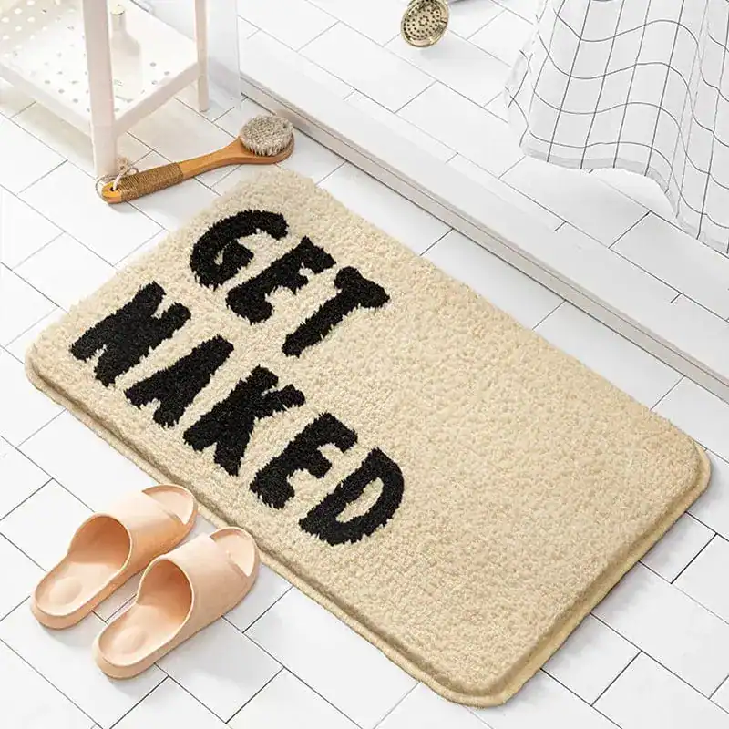 Badrumsmatta Get Naked i beige med svart text, mjuk och vattentät för badrummet.