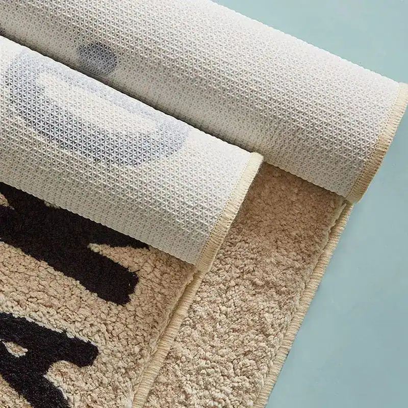 Badrumsmatta Get Naked i beige, textil med texturerad botten och svarta grafiska mönster.