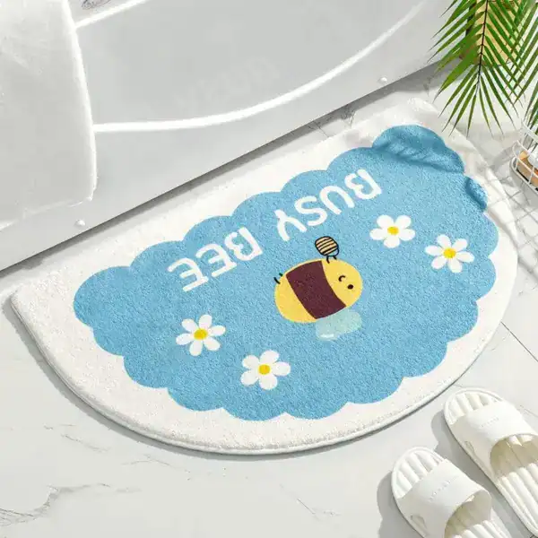Badrumsmatta Halvmåne Bi, blå och vit, med tecknad bi och vita blommor.