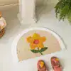 Halvmåneformad badrumsmatta med blomkonst i gult och grönt, mjuk och färgglad för badrummet.