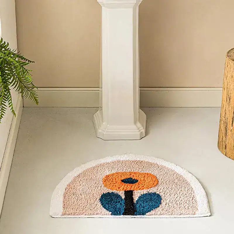 Halvmåneformad badrumsmatta med blomkonst i orange och blått, mjuk och färgglad för badrummet.