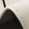 Vit badrumsmatta i kattform, närbild på mjuk textil och kant.