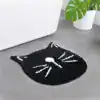 Svart kattformad badrumsmatta med vita detaljer, lämplig för badrummet.
