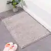 Badrumsmatta ljusgrön, mjuk och fuktbeständig, idealisk för badrum med grå kakel och badkar.