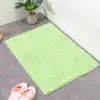 Ljusgrön badrumsmatta med mjuk, fluffig textur vid badkar, idealisk för badrummet.