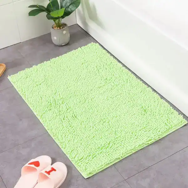 Ljusgrön badrumsmatta med mjuk, fluffig textur vid badkar, idealisk för badrummet.
