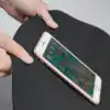 Svart badrumsmatta med marmormönster, visad med mobiltelefon för att visa tjocklek och kvalitet.