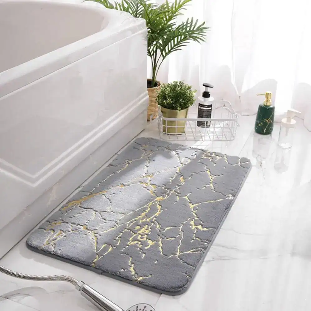 Badrumsmatta med marmormönster i svart och guld, idealisk för badrum med stil och modern design.