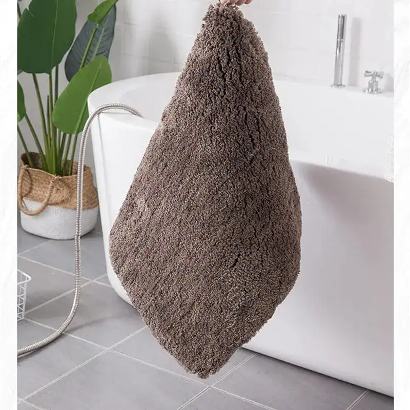 Mörkbrun badrumsmatta med fluffig textur, idealisk för badrummet med vatten och skötsel.