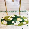 Badrumsmatta Mossa Blommor, grön med vita och gula blommor, mjuk och dekorativ för badrum.