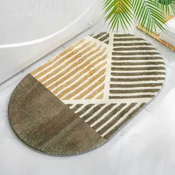 Oval grön badrumsmatta med geometriska mönster och beige detaljer.