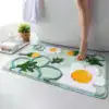 Grön badrumsmatta med blommig mönster och prästkragar, idealisk för badrummet.