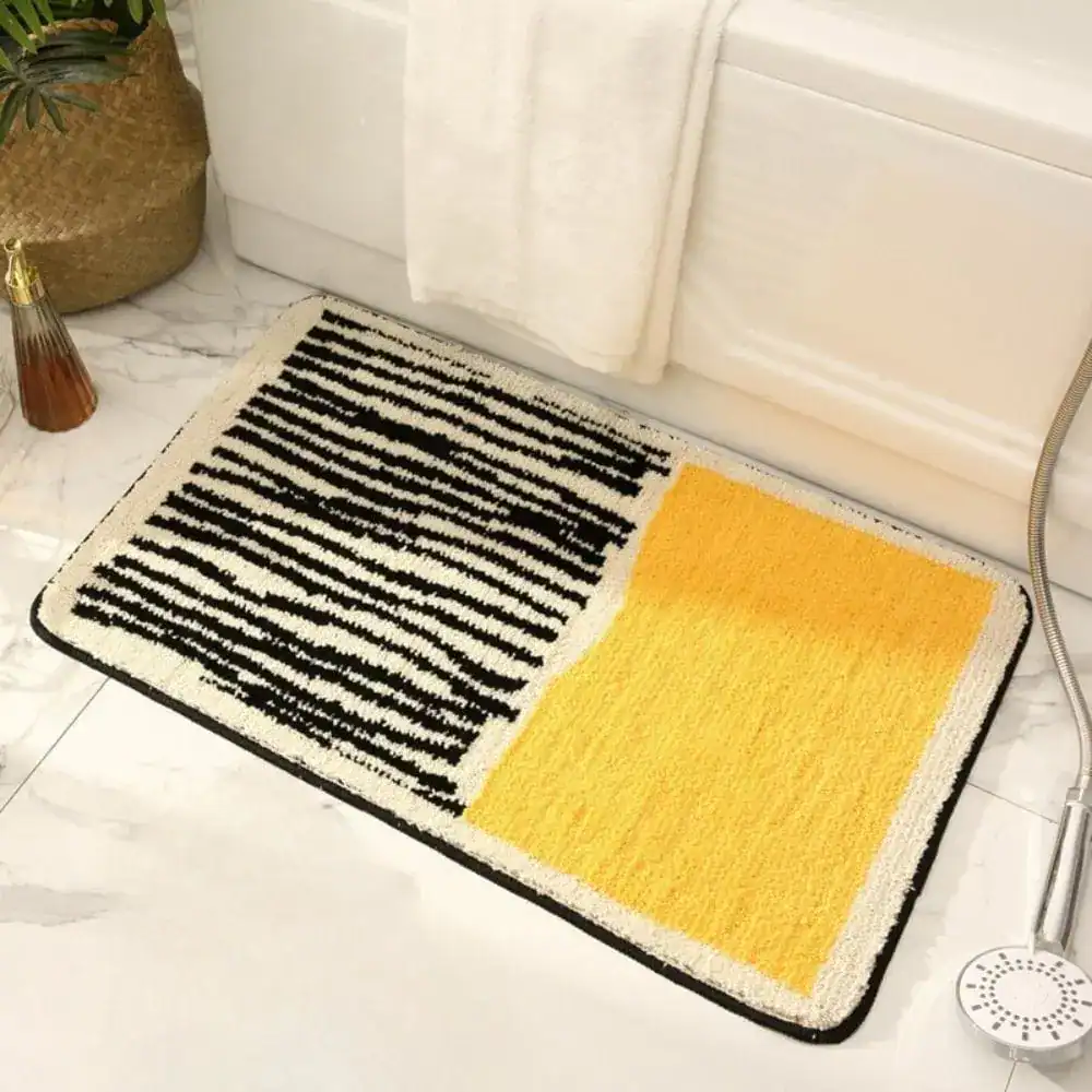 Badrumsmatta med svartvita prickar och gul färgblock, modern design för badrum.