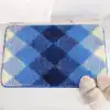 Badrumsmatta med rutmönster i blå och grå nyanser, mjuk textil och vattentät design för badrum.