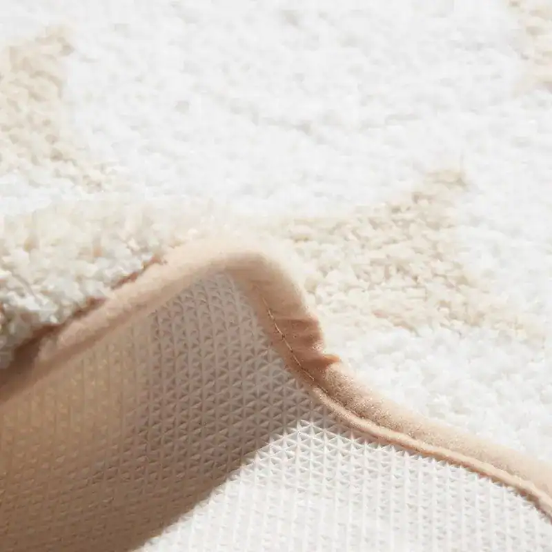 Badrumsmatta med stenmönster i vit färg, mjuk textil och antiskridande undersida.
