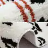 Badrumsmatta med tigermönster i svart, vitt och orange, mjuk fluffig textur.
