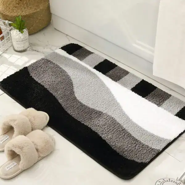Badrumsmatta med vågmönster i grått, svart och vit, mjuk textil, badrumsmatta för badkar.