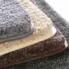 Beige badrumsmatta med fluffig textur och mjuk yta, idealisk för badrummet.