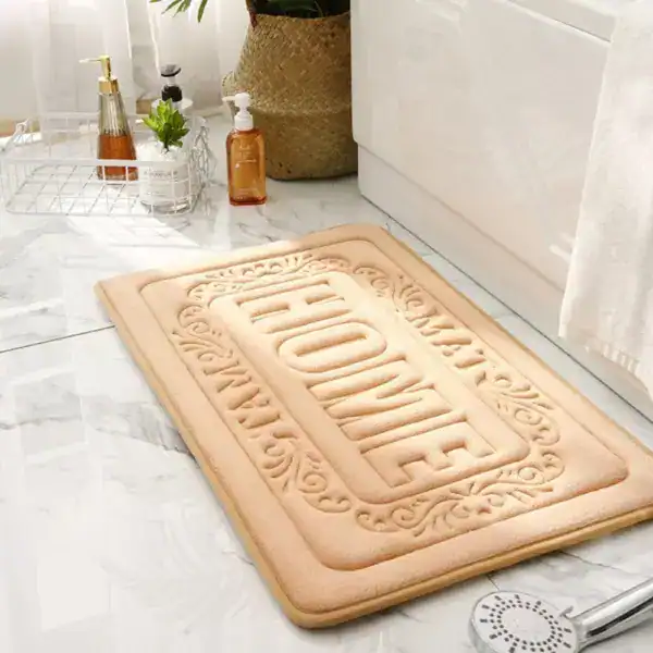 Beige badrumsmatta med präglat 'HOME'-motiv, idealisk för badrummet.