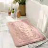 Beige badrumsmatta med präglat 'HOME'-motiv, idealisk för badrummet.