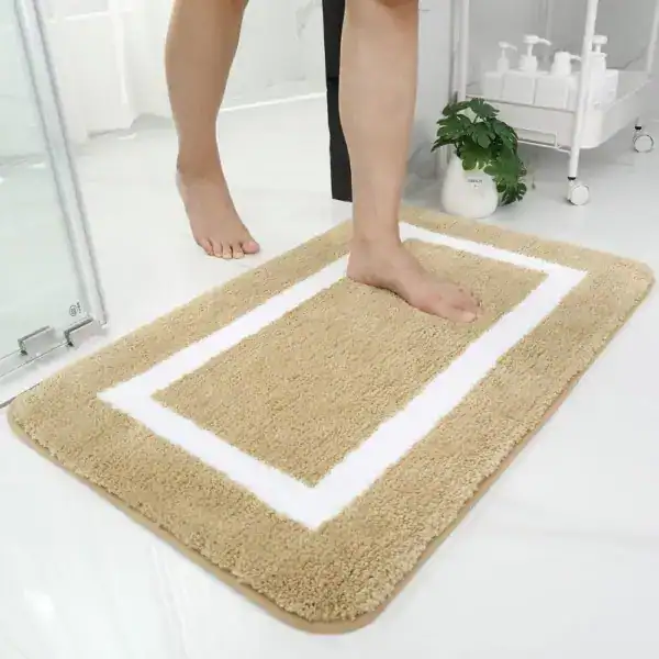 Beige badrumsmatta med vit ram, mjuk och vattentät för badrummet.