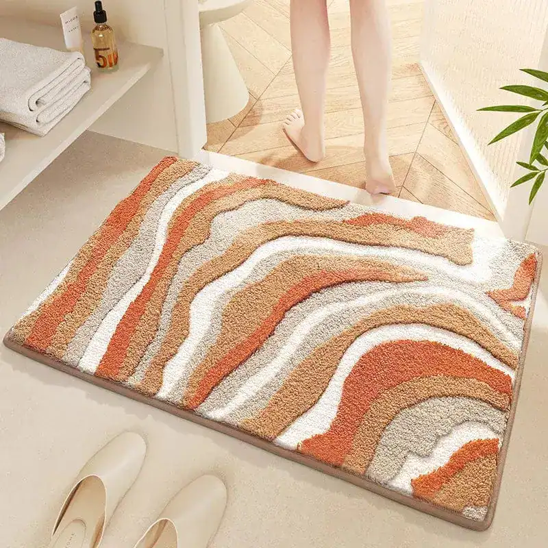 Blå badrumsmatta med vågformad mönster i orange och beige, mjuk och vattentät för badrummet.