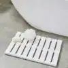 Vit bambuduschmatta med sladdig design, idealisk för badrummet med modern stil och praktiskt material.