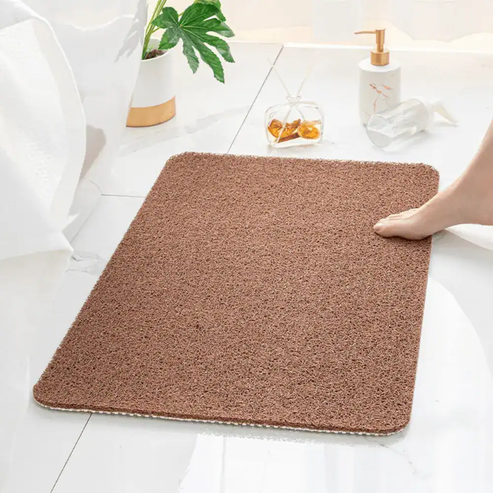 Grå duschmatta Loofah med texturerad yta och rundade kanter i badrummet.