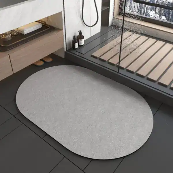 Oval grå duschmatta i badrummet, modern design, vattentät och slipad.
