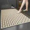 Stor duschmatta i beige med golvdränkande design för badrum.