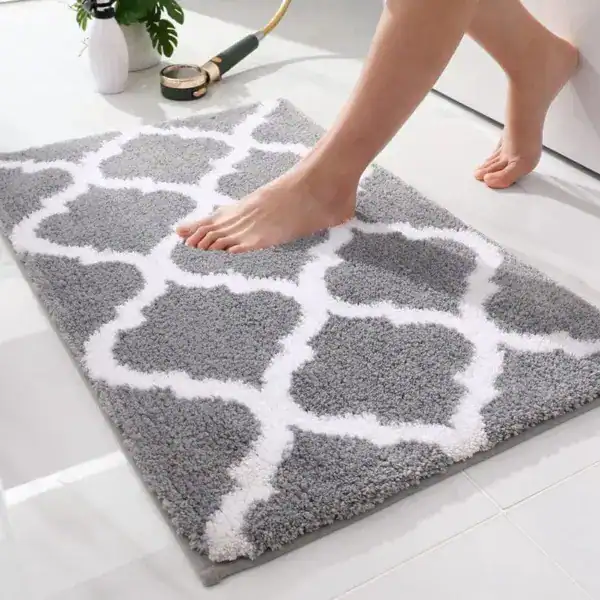 Fluffig badrumsmatta i grått med vit geometrisk mönster, mjuk och mjuk under foten.