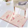Fluffig badrumsmatta i mossgrön med rosa detaljer och mjuk textur för badrummet.
