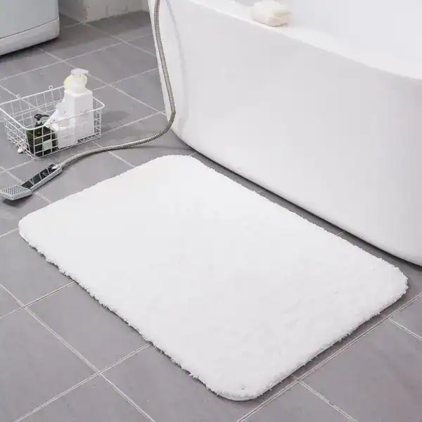 Fluffig badrumsmatta i vit färg, mjuk och mjuk på badrumsgolv.