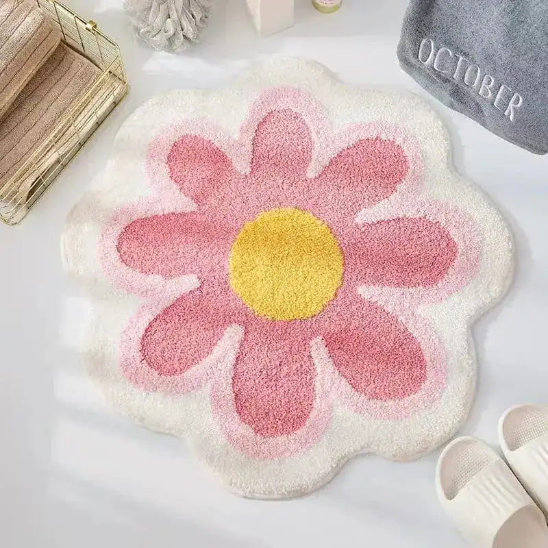 Gul badrumsmatta i blommaform med rosa och vit färg, mjuk och rundad kant.