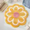 Gul badrumsmatta i blommaform med vit och rosa detaljer, mjuk och färgstark för badrummet.