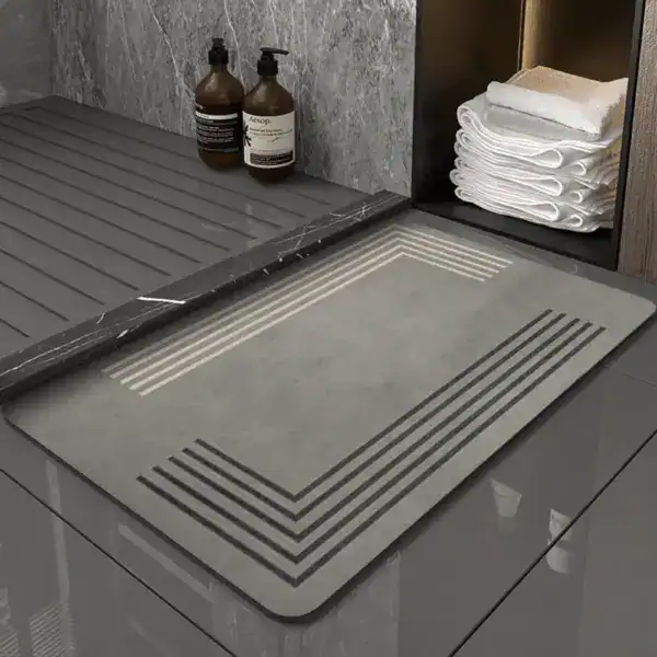 Grå duschmatta med gummikant och vattensänkor för badrum, modern design.
