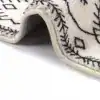 Lång badrumsmatta i boho-stil med svart-vit geometriskt mönster och mjuk textil.