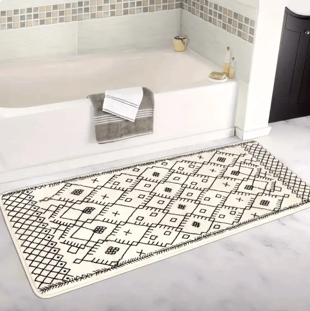 Lång badrumsmatta med boho-mönster i svart och vit, placerad framför badkar.