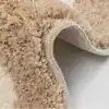 Liten badrumsmatta med mönstrad design och mjuk, fluffig textur i beige och vit.