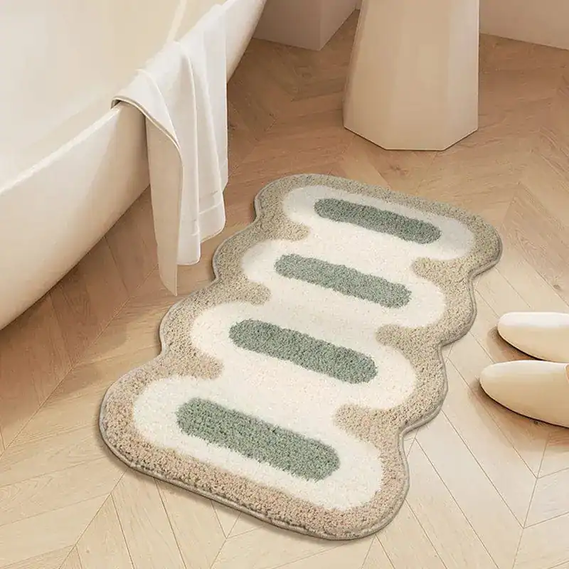 Liten badrumsmatta med mönster, grön och beige, i badrummet vid badkar.
